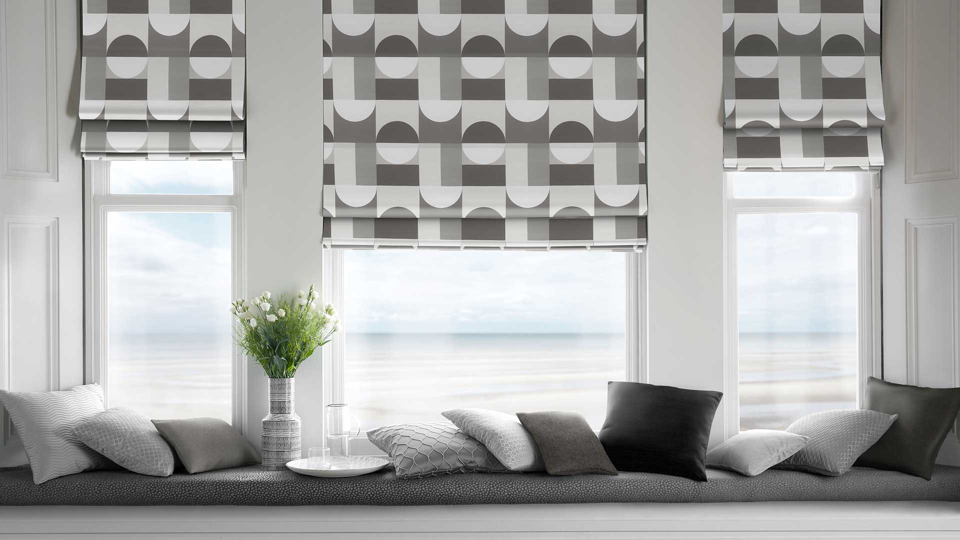 Patterned Roman Blinds Against lounge room cushions and chair